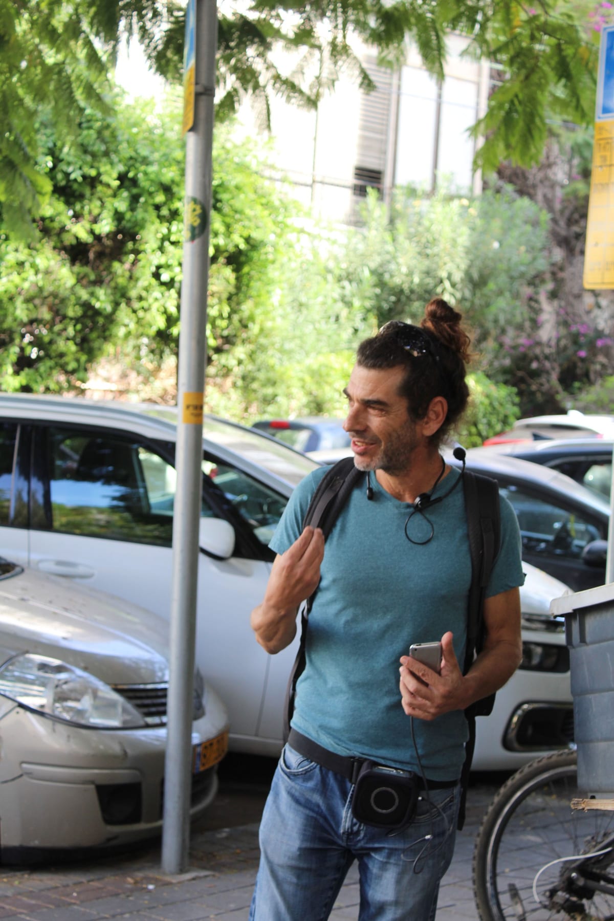 רענן לוי מדריך סיור ברחוב בתל אביב, עם מיקרופון ראש