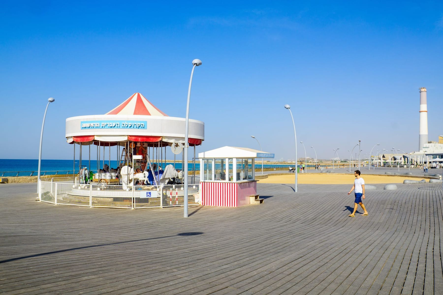 טיילת תל אביב עם ביתן עגול ומגדלי תחנת הכוח רדינג ברקע
